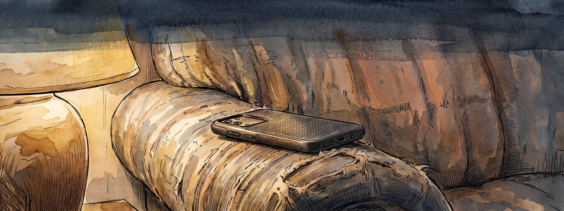 A mobile phone lying face down on a couch cushion in low lamplight.