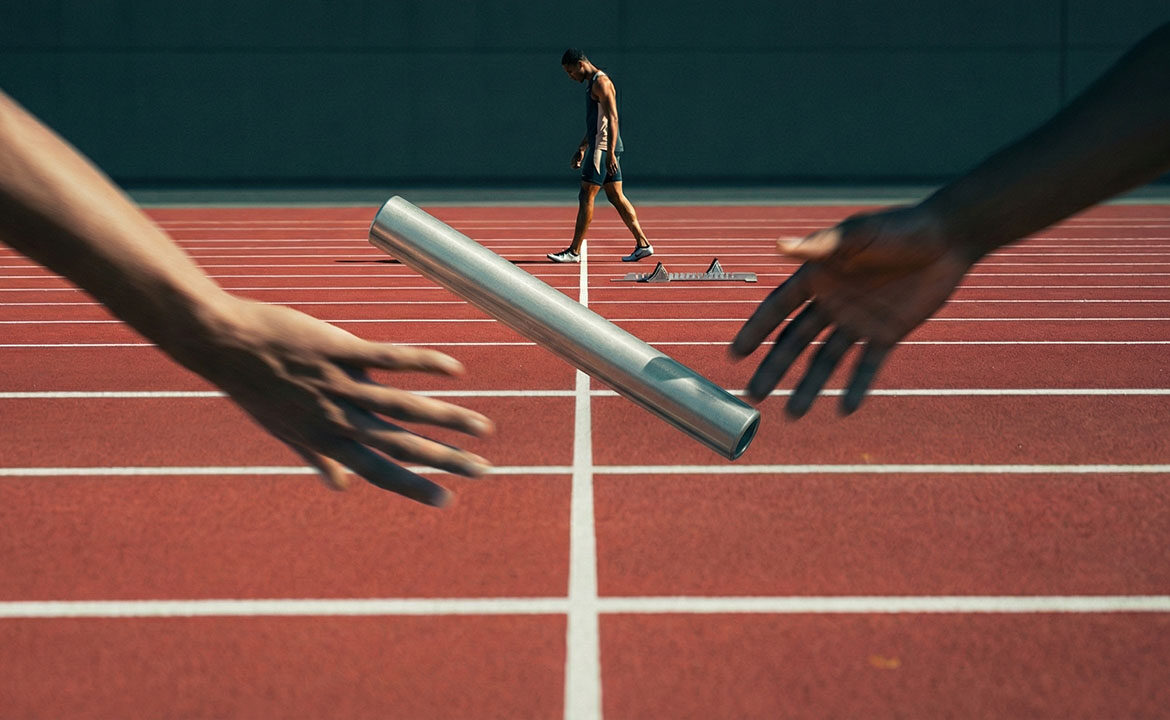 A relay baton suspended mid-air between two blurred hands during a failed handoff, with a solo runner in sharp focus already past the finish line in the background.